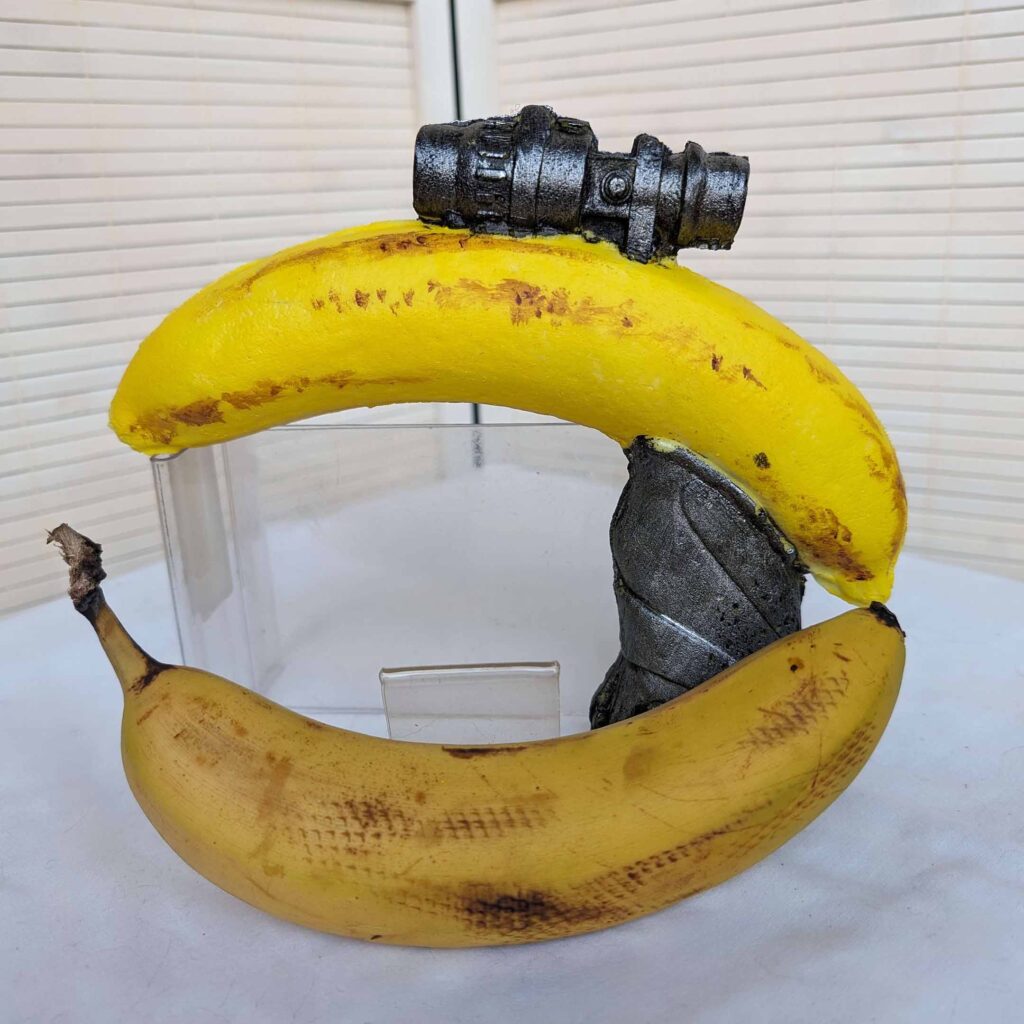 Picture of a foam gun made out of a banana with handle and scope (with real banana for scale).